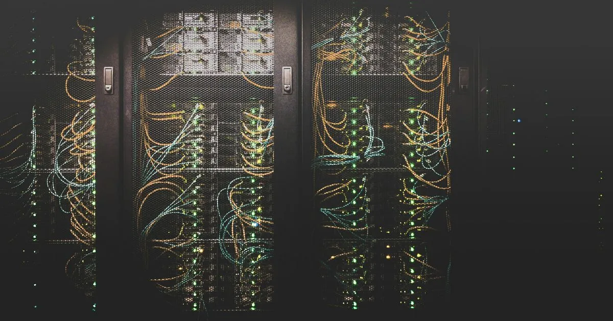 Serverschränke mit Netzwerkkabeln in einem dunklen Rechenzentrum